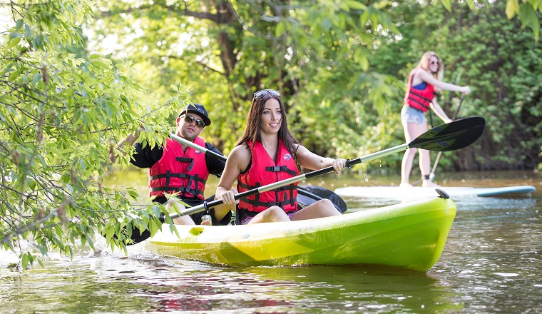 Two people kayaking and one person paddleboarding
